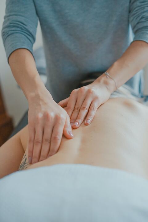 Therapeutin führt eine entspannende Rückenmassage durch, um Muskelverspannungen zu lösen.
